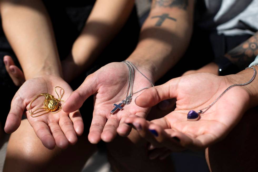 Kyla Dominguez, Von Dominguez and Ricky Dominguez hold keepsake necklaces at their mother's hom ...