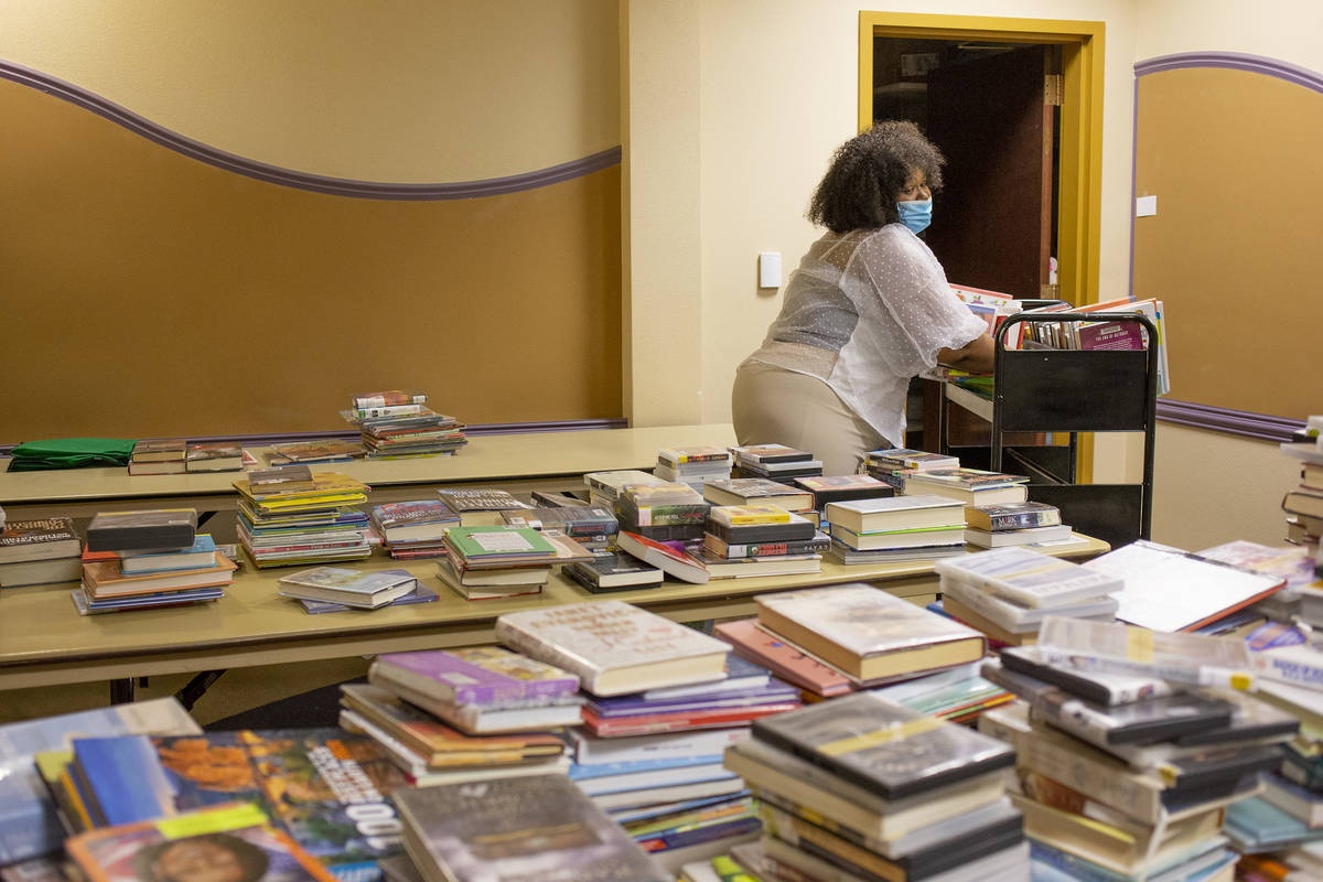 Jasmine Haynes, a library assistant, loads books to be checked back in at Aliante Library on We ...