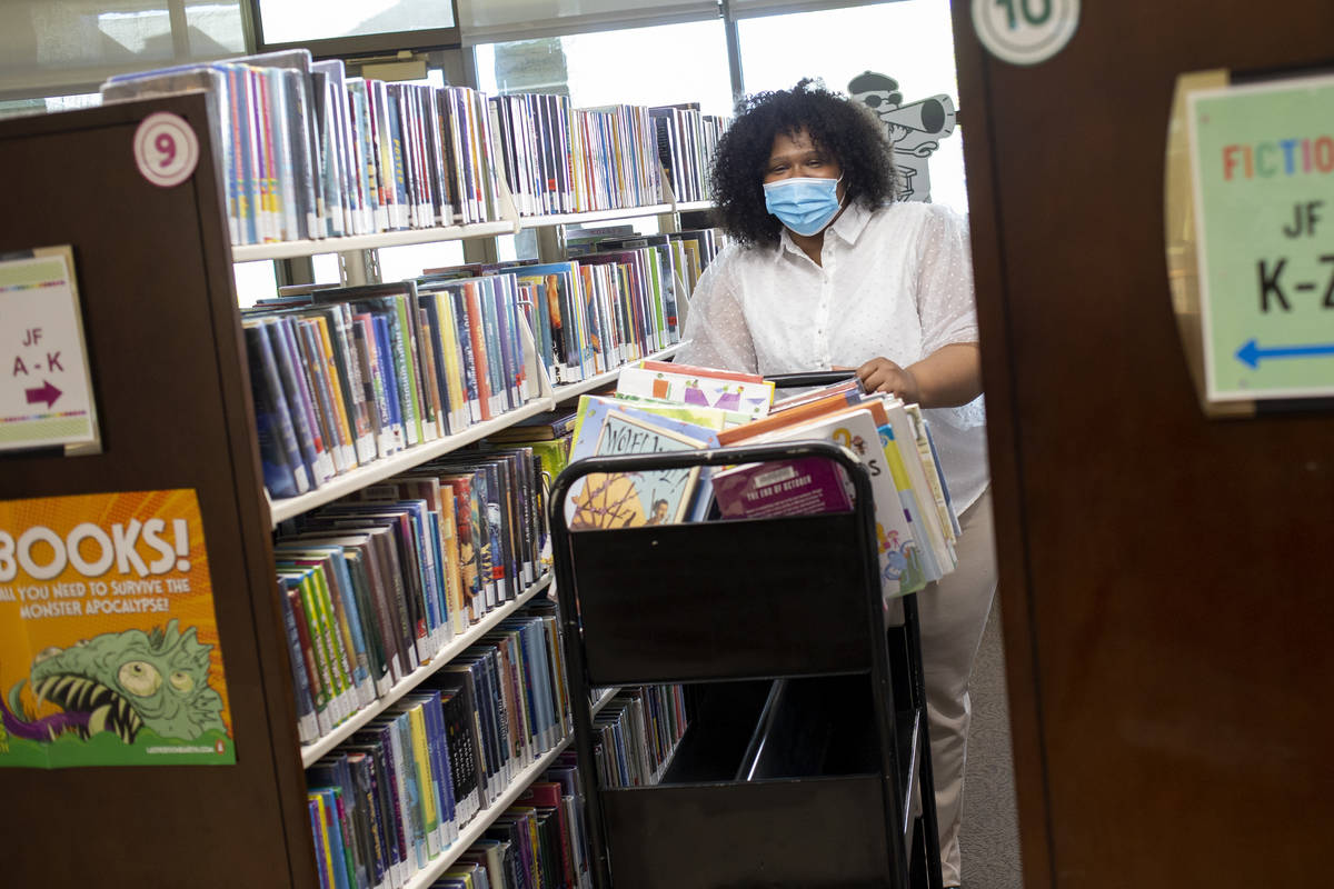 Library assistant Jasmine Hughes transports books to be re-entered into circulation at Aliante ...