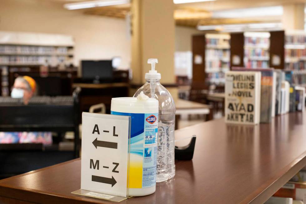 Hand sanitizer and antibacterial wipes are available for use as workers keep the library runnin ...