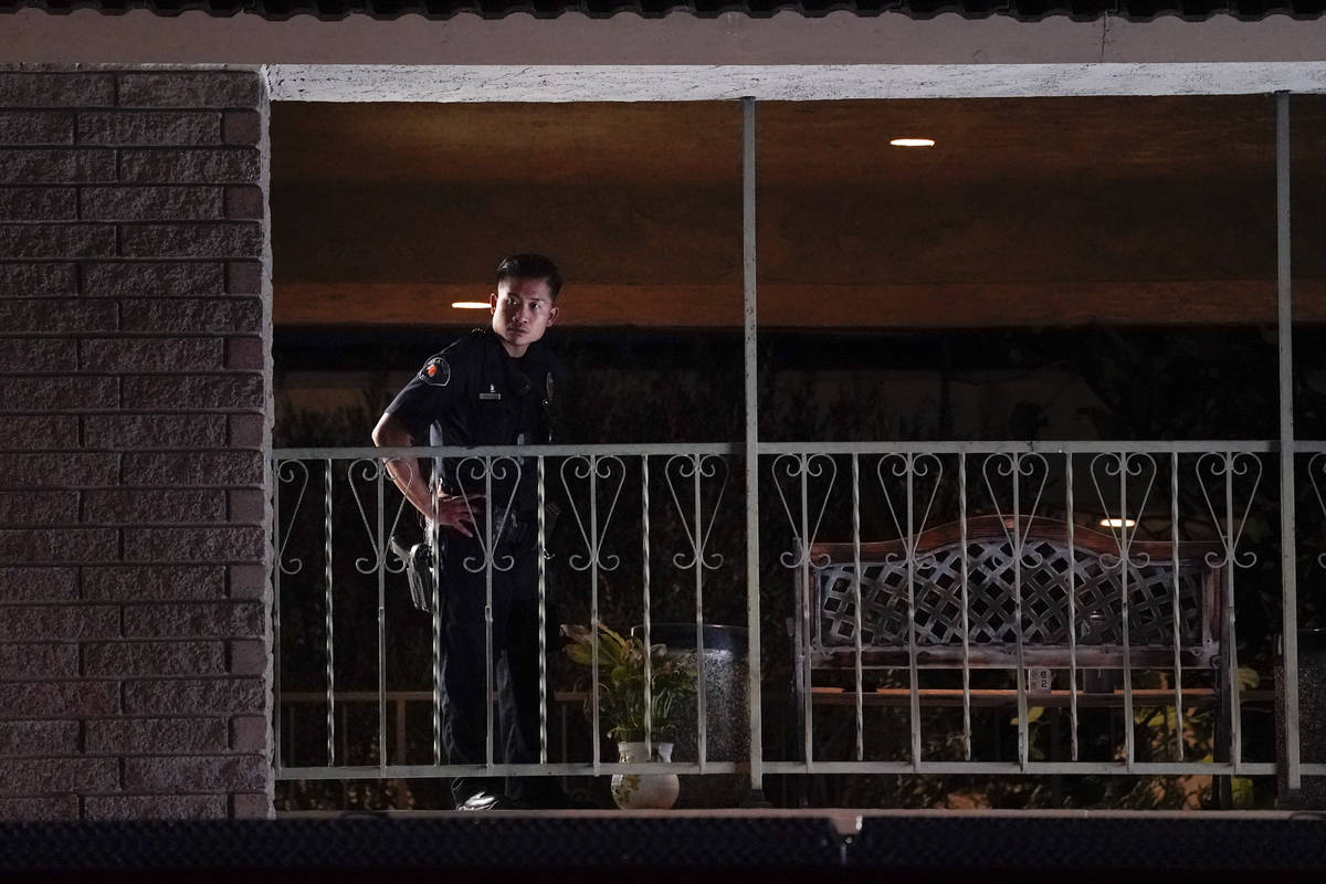 A police officer surveys the scene after a shooting at an office building in Orange, Calif., We ...