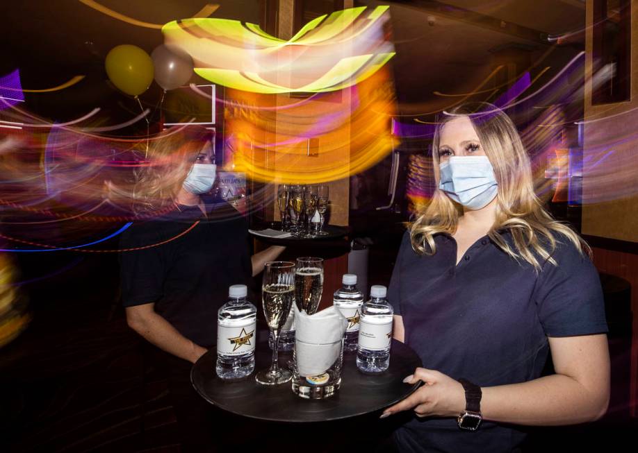 Server Audrea Doan delivers drinks to guests during the VIP opening party for The Pass casino o ...