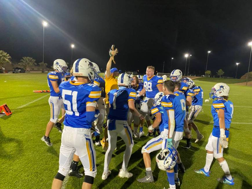 Moapa Valley coach Brent Lewis celebrates with the hammer as players circle around after the Pi ...