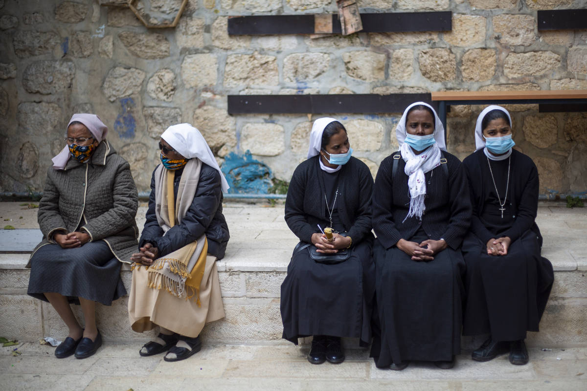 Nuns wait to the Good Friday procession along the Via Dolorosa near the Church of the Holy Sepu ...