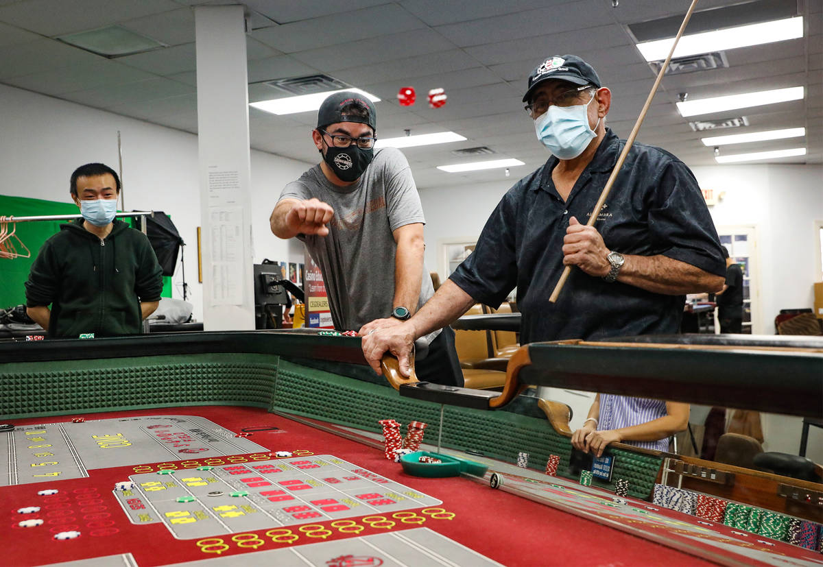 Bruce Lin, from left, plays craps with Marc Heslet, center, and dice coach Ronnie Binkier, righ ...