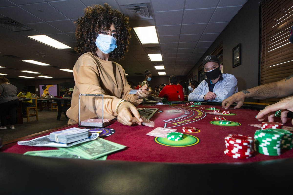 Instructor Yodit Girma, left, deals cards while working a blackjack table with students, includ ...