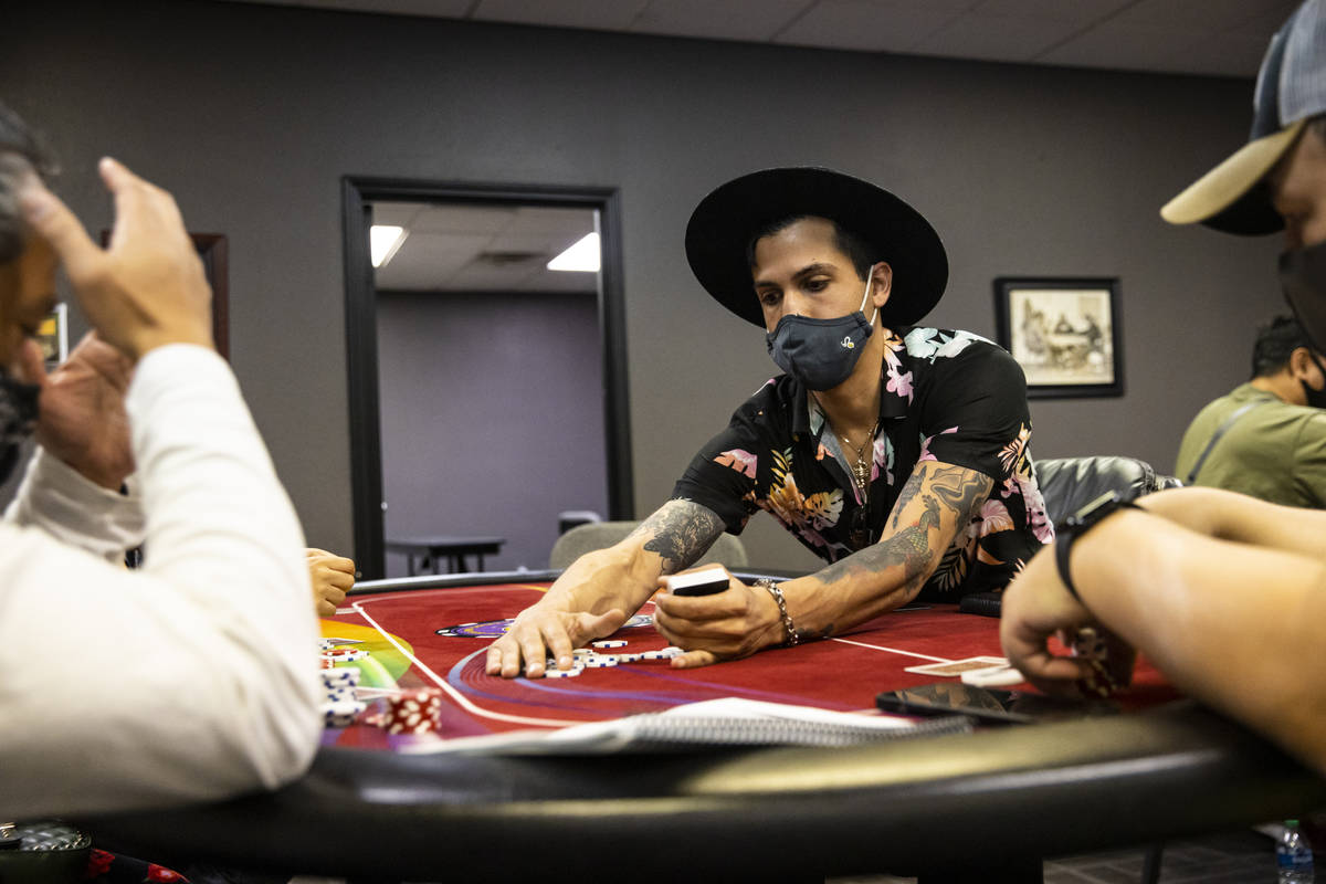 Student Christopher Montenegro, right, collects chips while working a poker table during class ...