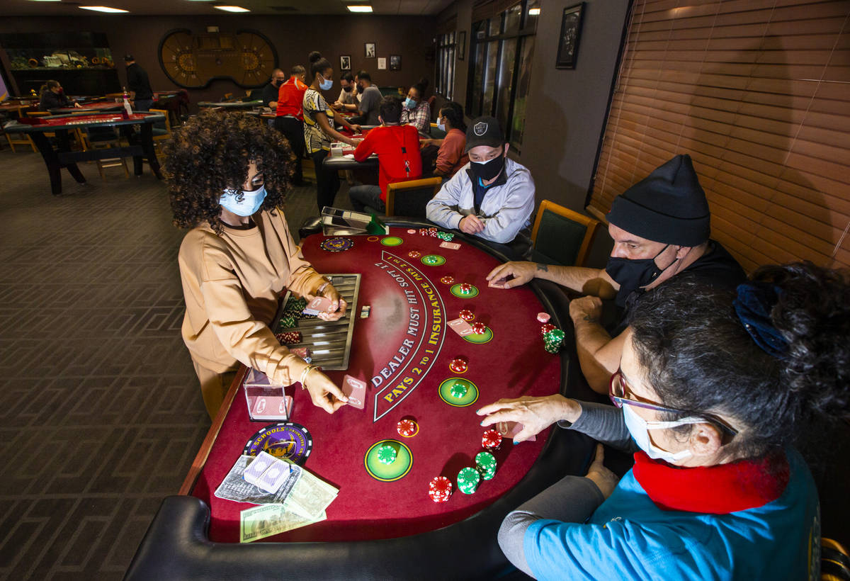 Instructor Yodit Girma, left, deals cards while working a blackjack table with students, from l ...