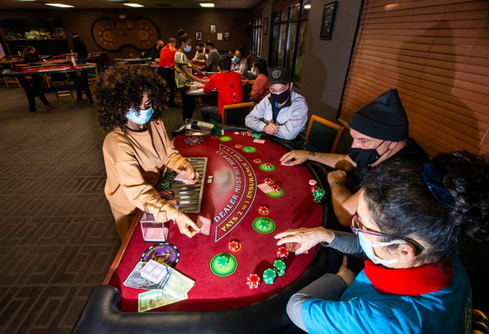 Instructor Yodit Girma, left, deals cards while working a blackjack table with students, from l ...