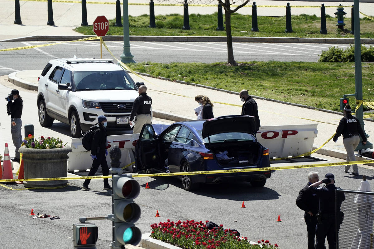 U.S. Capitol Police officers investigate near a car that crashed into a barrier on Capitol Hill ...
