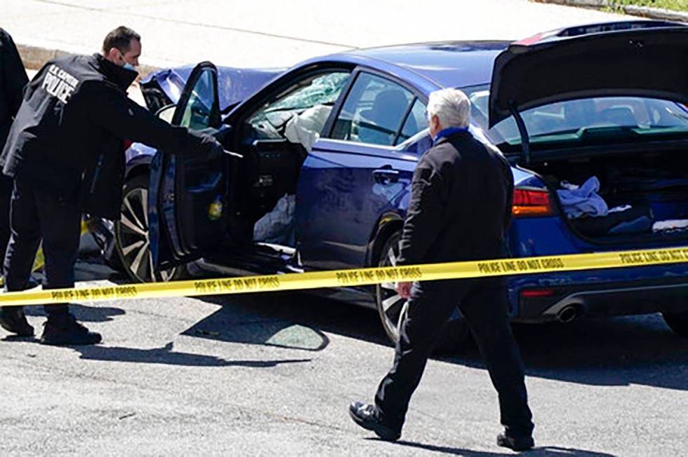 U.S. Capitol Police officers stand near a car that crashed into a barrier on Capitol Hill in Wa ...