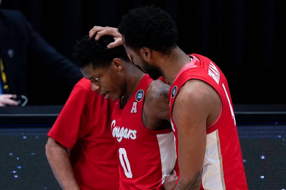 Houston guard Marcus Sasser (0) walks off the court with teammate forward Justin Gorham, right, ...