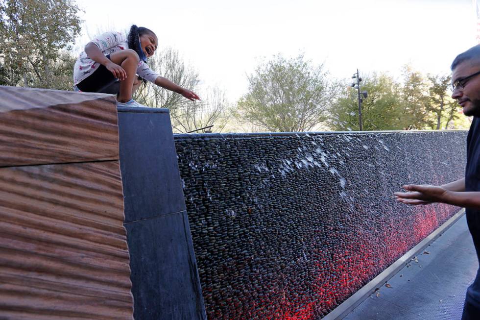 Maia Olivas, 6, of Houston, Texas cools off near the water walls with her father Juan at The Pa ...