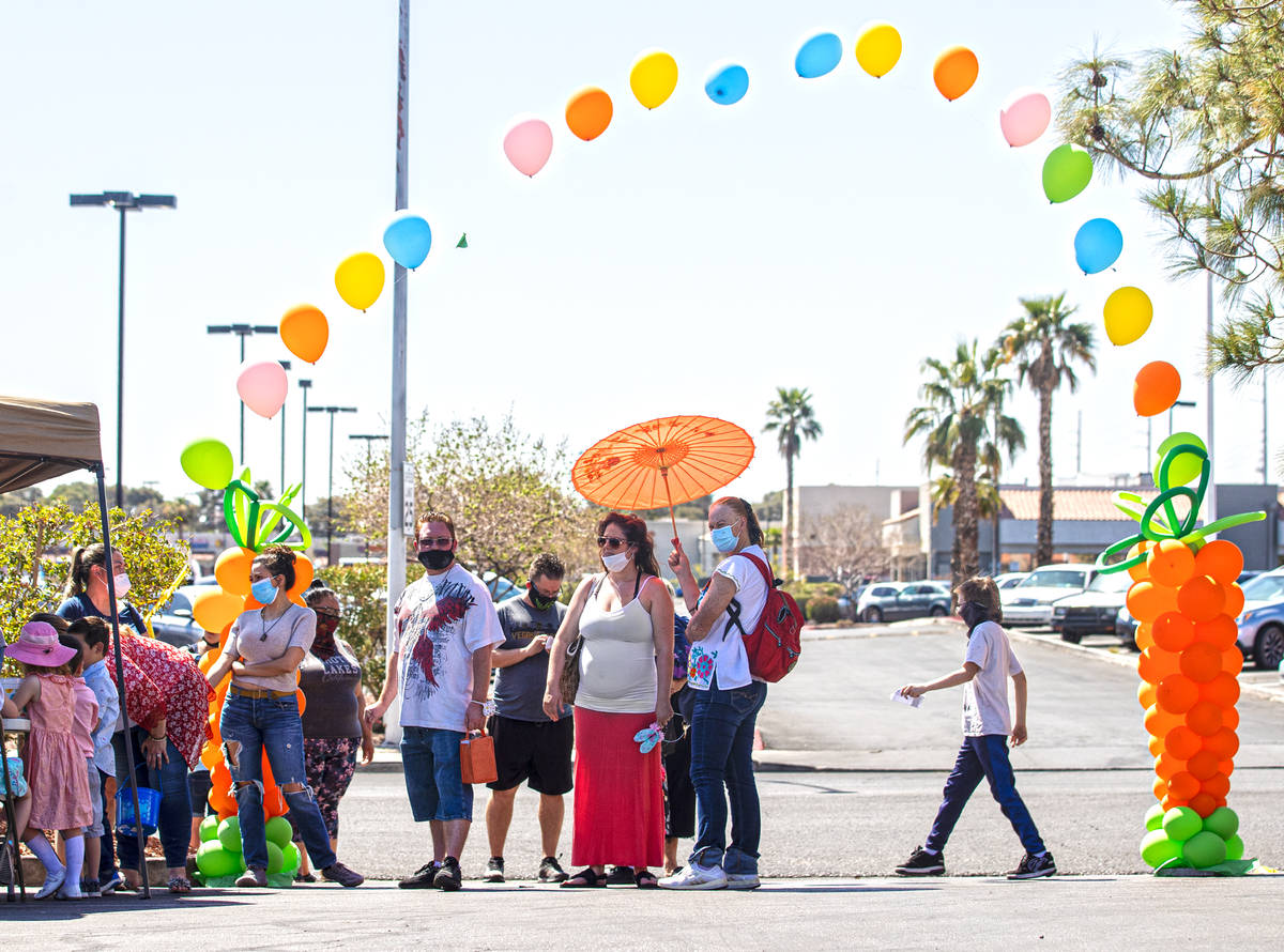 People wait to check in during an Easter egg hunt and carnival sponsored by The JET Foundation, ...