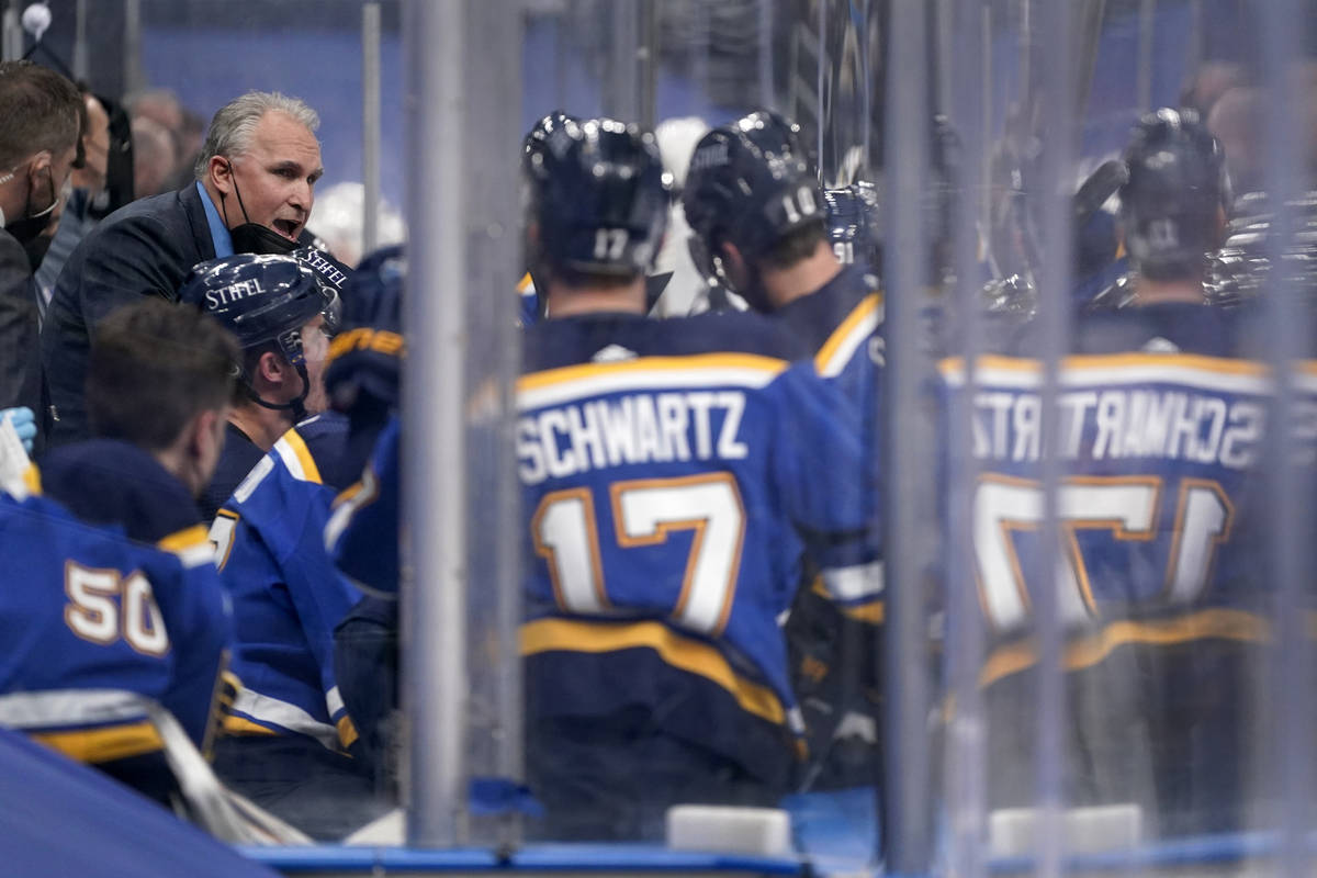 St. Louis Blues head coach Craig Berube, left, talks with his team during the second period of ...