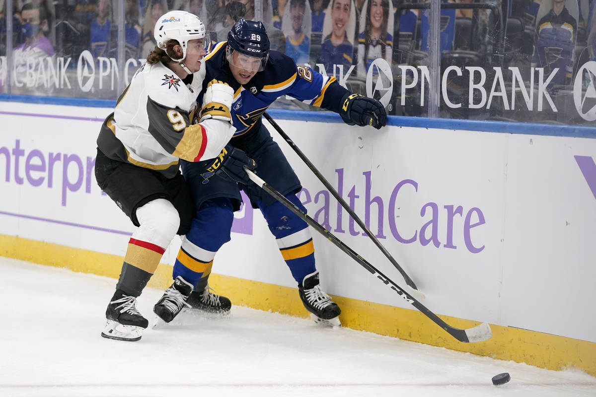St. Louis Blues' Vince Dunn (29) and Vegas Golden Knights' Cody Glass (9) chase after a loose p ...