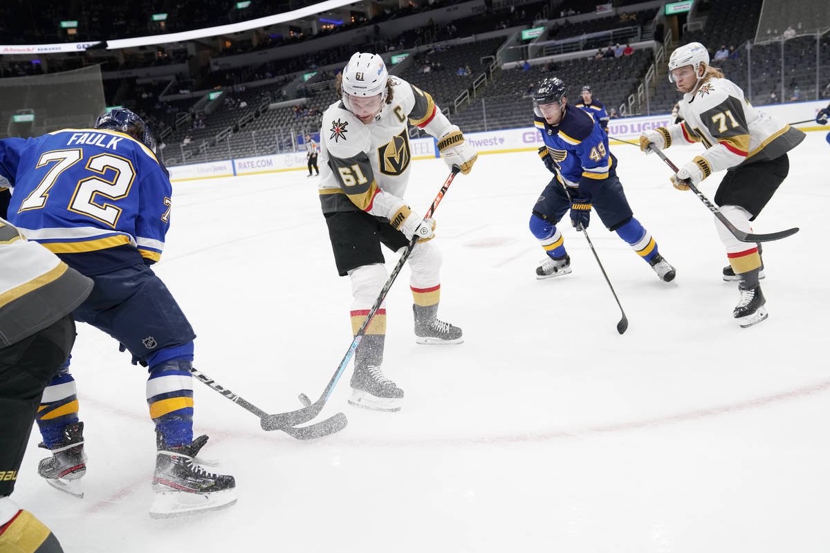 Vegas Golden Knights' Mark Stone (61) and St. Louis Blues' Justin Faulk (72) reach for a loose ...