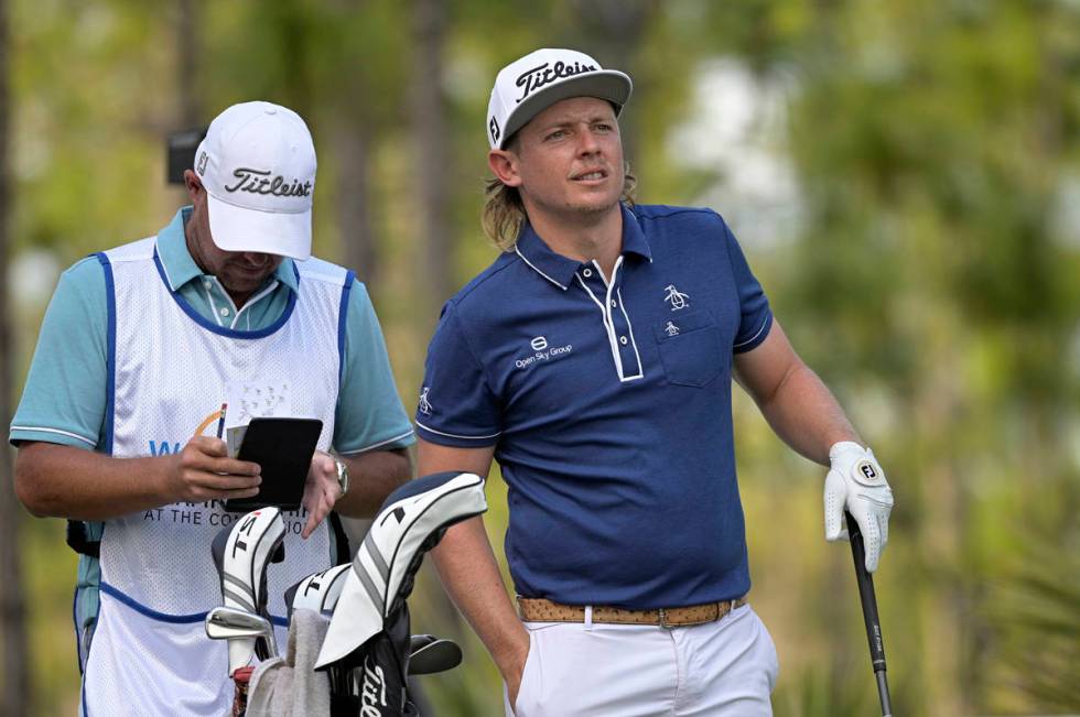 Cameron Smith, right, of Australia, waits to hit his tee shot on the second hole during the thi ...
