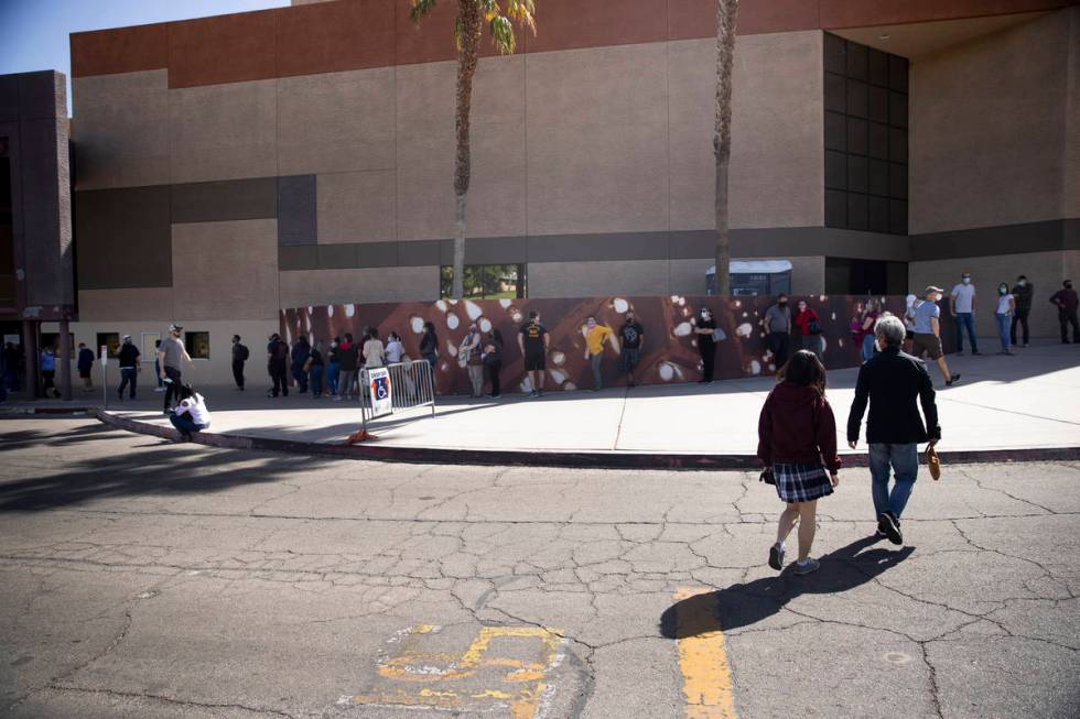 People wait in line to receive the COVID-19 vaccine at the Cashman Center in Las Vegas, Tuesday ...
