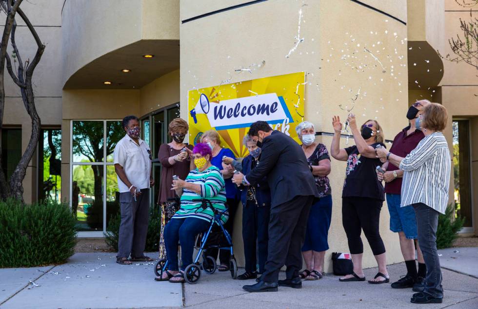 Clark County Commissioner Michael Naft, center, helps a senior as they use streamers and confet ...