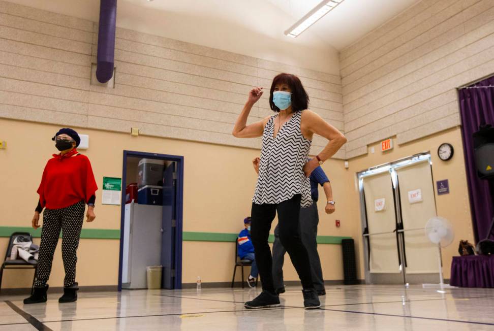 Terry Harris, 78, center, participates during a line dancing class at the West Flamingo Senior ...