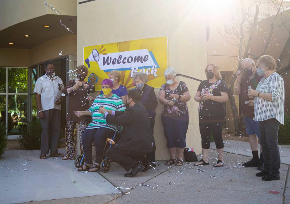 Clark County Commissioner Michael Naft, center left, assists Dotty Ducret, sitting, as seniors ...