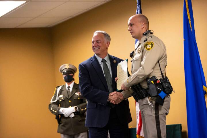 Sheriff Joe Lombardo presents police officer Jovan Magazin with an award for lifesaving efforts ...