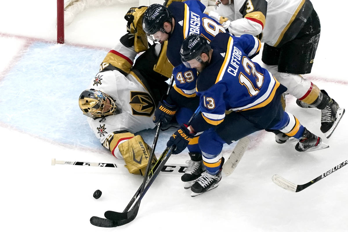 Vegas Golden Knights goaltender Marc-Andre Fleury, left, reaches for a puck along with St. Loui ...