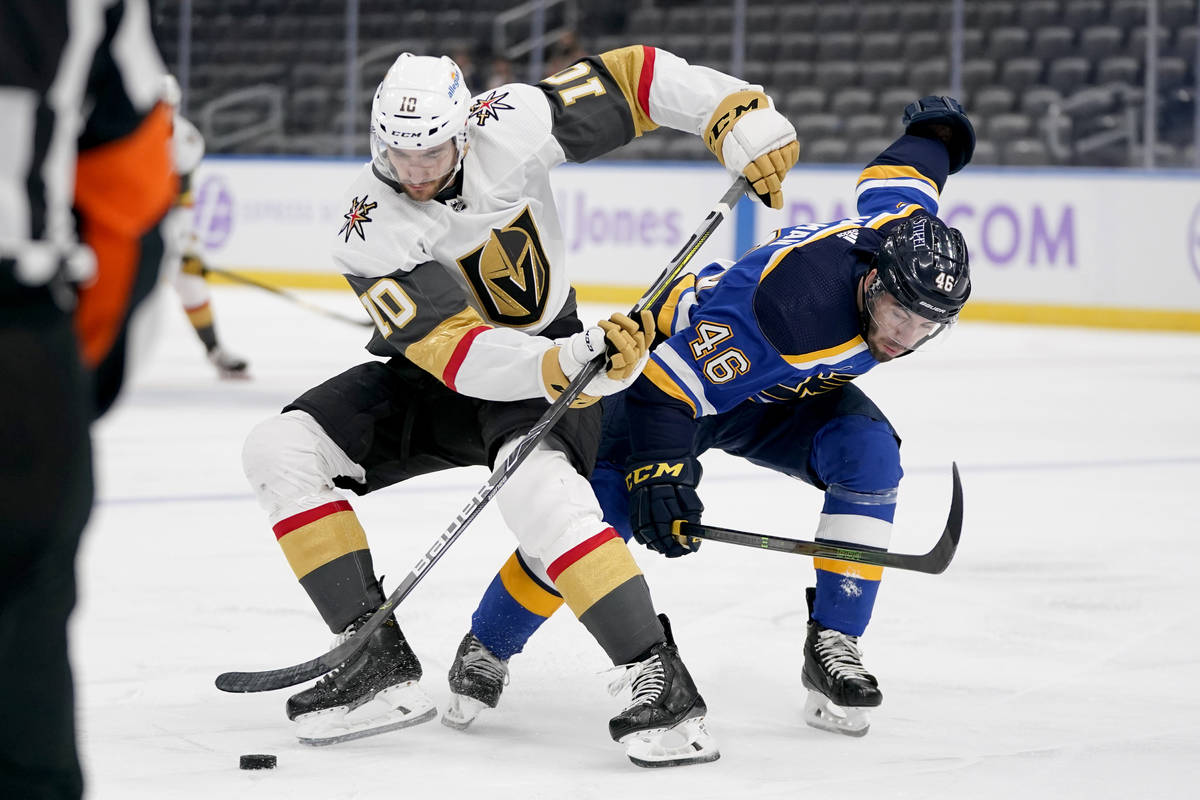 Vegas Golden Knights' Nicolas Roy (10) and St. Louis Blues' Jake Walman (46) battle for a loose ...