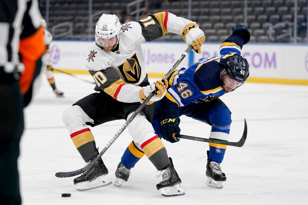 Vegas Golden Knights' Nicolas Roy (10) and St. Louis Blues' Jake Walman (46) battle for a loose ...