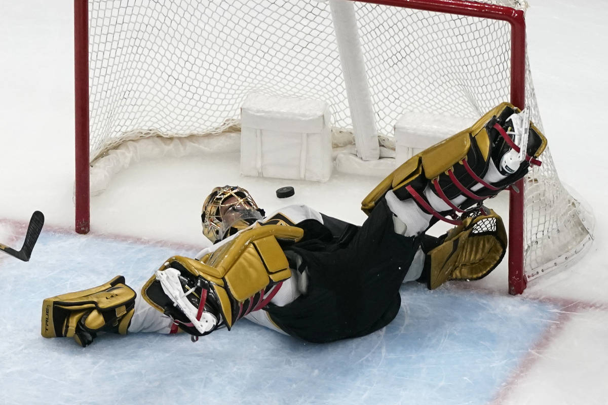 Vegas Golden Knights goaltender Marc-Andre Fleury slips as a puck flies by during the third per ...