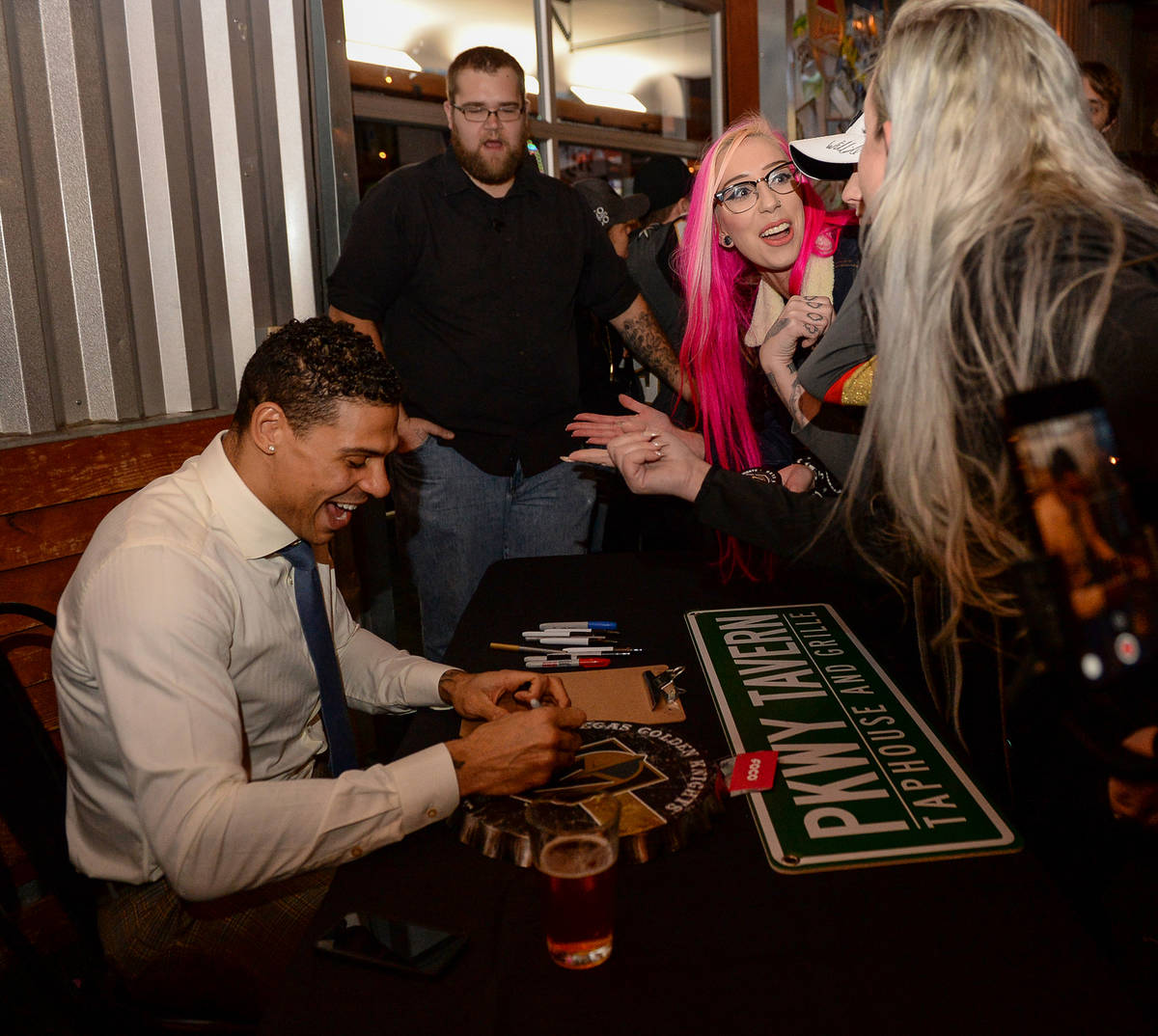 Vegas Golden Knights player Ryan Reaves signs memorabilia for fans at a party for the release o ...