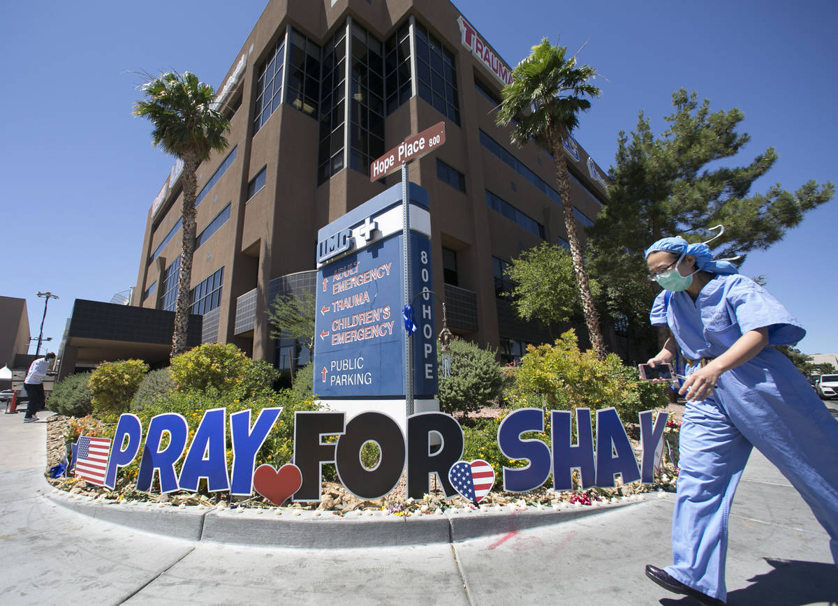 A nurse at University Medical Center (UMC) walks past a sign reading "Pray for Shay" ...