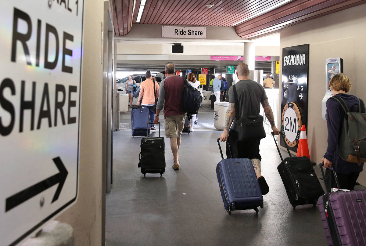 Riders arrive at ride-hailing companies' Uber and Lyft pick up area at McCarran International A ...