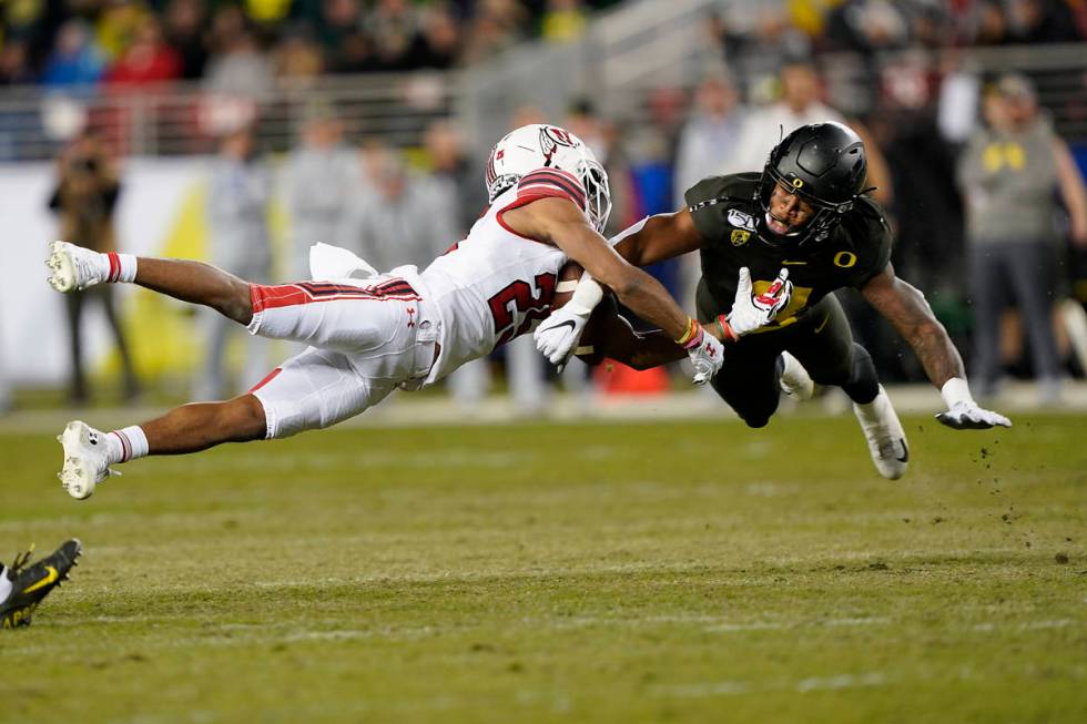 In this Dec. 6, 2018, file photo, Oregon safety Jevon Holland (8) breaks up a pass for Utah wid ...