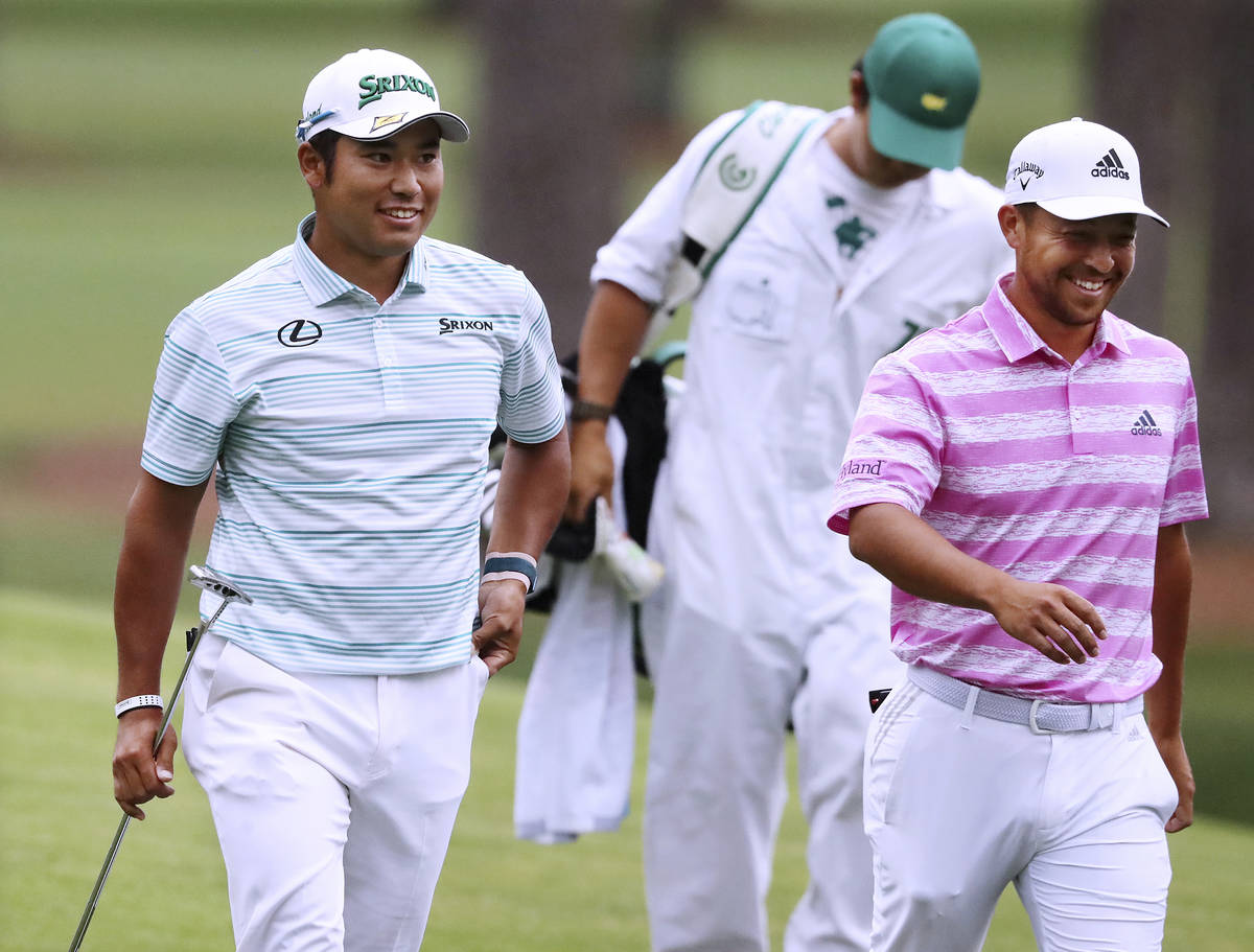 Hideki Matsuyama, left, and Xander Schauffele smile after they both made eagle putts on the 15t ...