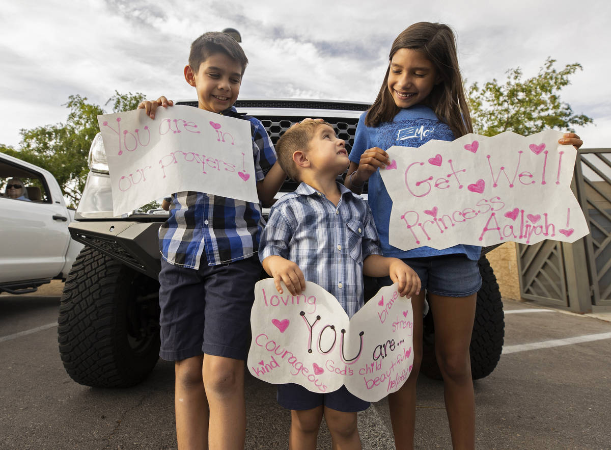 Asher, 9, Angelo, 3, and Arabella, 9, hold signs to support 9-year-old Aaliyah Velasquez, who w ...