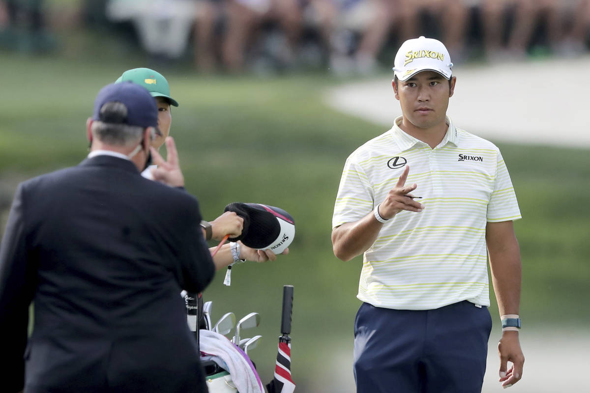 Hideki Matsuyama talks with a rules official after his ball went in the water on the fifteenth ...