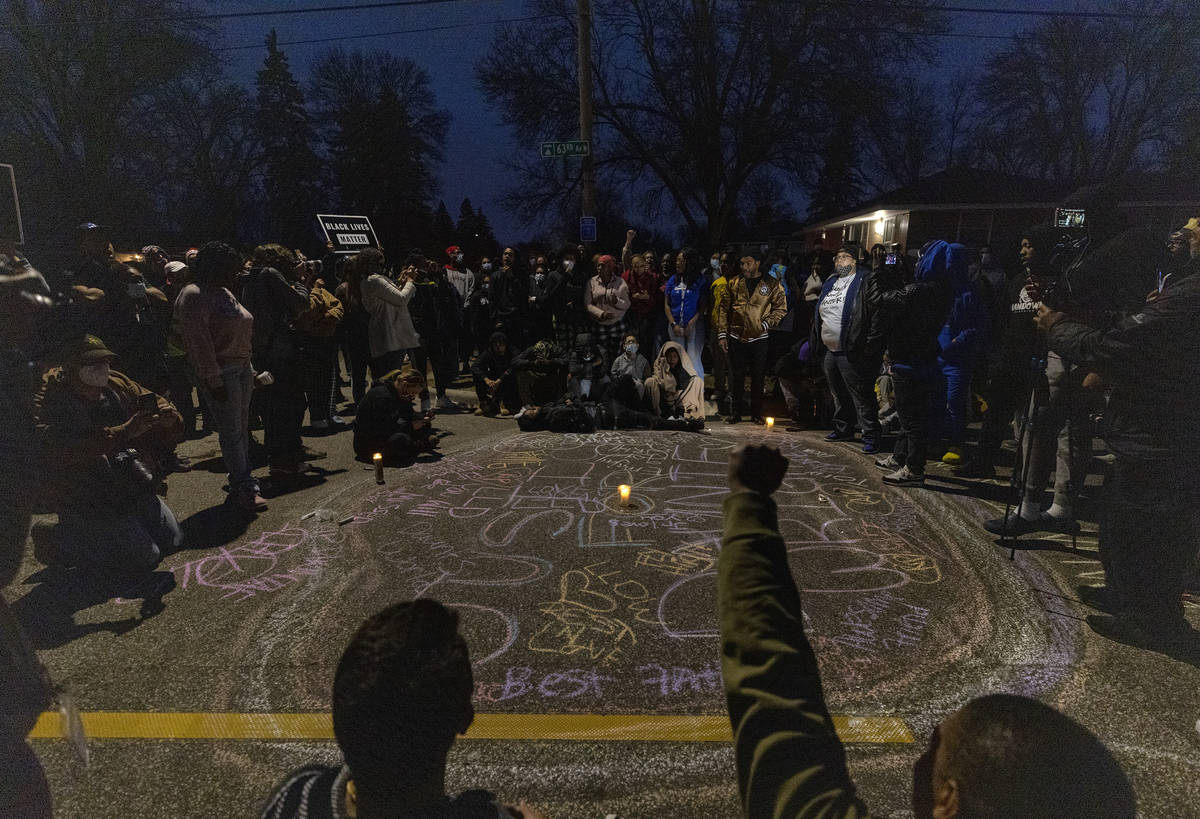 A crowd forms a circle around a memorial for Daunte Wright, in Brooklyn Center, Minn., Sunday, ...