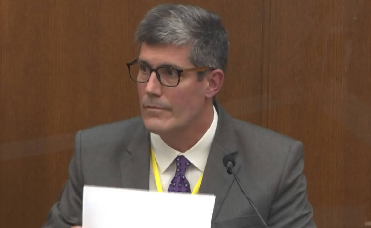 In this image from video, Dr. Andrew Baker, Hennepin County Medical Examiner, testifies as Henn ...