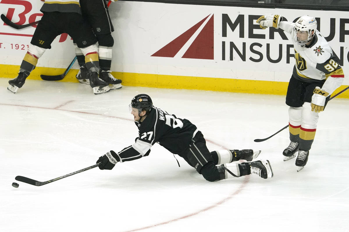 Los Angeles Kings left wing Austin Wagner, left, falls as he passes the puck while under pressu ...