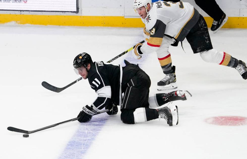Los Angeles Kings center Anze Kopitar, left, trips while under pressure from Vegas Golden Knigh ...