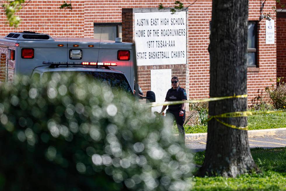A member of the Knoxville police forensics team works the scene of a shooting at Austin-East Ma ...