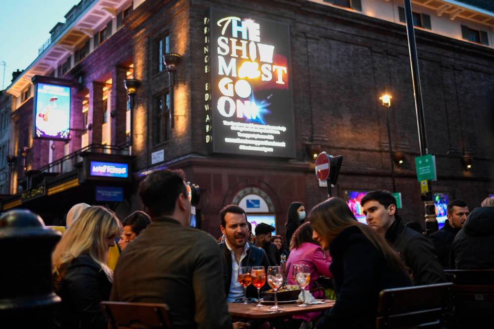 People sit at setup tables outside a pub in Soho, in London, on the day some of England's third ...