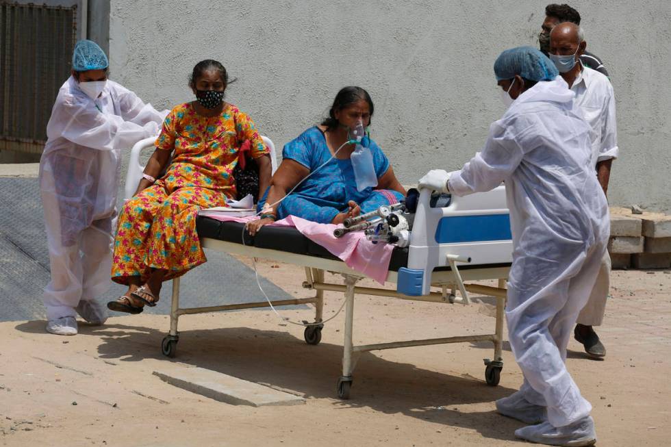 Health worker carry patients to shift them from a dedicated COVID hospital to another hospital ...