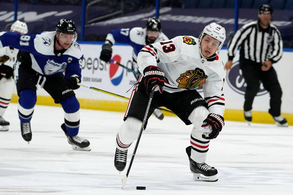 Chicago Blackhawks center Mattias Janmark (13) breaks out ahead of Tampa Bay Lightning center S ...