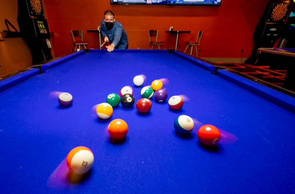Joseph Turnell breaks the balls while playing pool at Red Rock Lanes, which has electronic dart ...