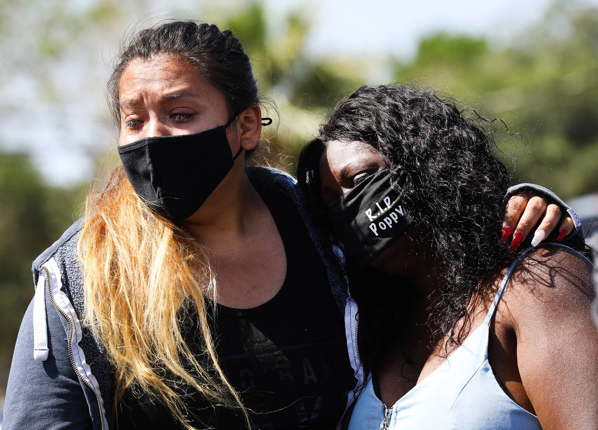 Jenifer Torres, left, wife of Kashif Brown, and Maria Levi, mother of Kashif Brown, right, comf ...