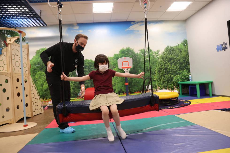 Akara Haase, 6, works with behavior analyst Adam Volker at the Center for Autism and Developmen ...