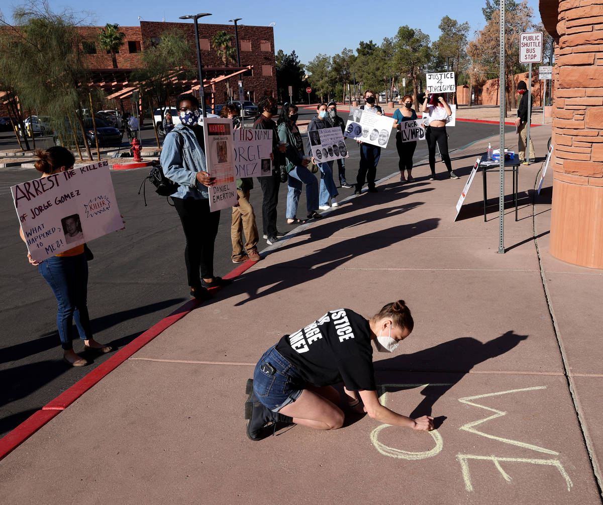 Jazz Appin writes messages in chalk on the ground outside the Clark County Government Center on ...